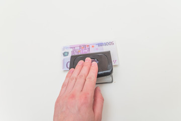 close - up, the man's hand presses the hole in which the bill is invested five hundred euros, money