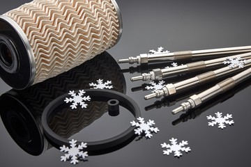 Four diesel engine glow plugs shot over dark blue background