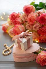 Fototapeta na wymiar Rose fresh flowers bouquet with jewelery boxes on gray table