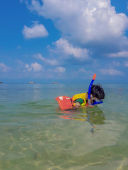 Boy wearing a life jacket, scuba diving in the sea at Haad salad Beach , koh Phangan  Suratthani Thailand.