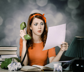 young woman as secretary at her desk near the typewriter and dial phone. 60-s style.