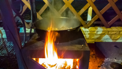 Cooking on an open fire in the cauldron at night.