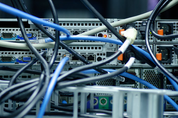 Tangled network cables and wires in server room for Unorganized cabling in data center concept