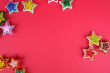 Christmas New Year star stars different colors made from beads handmade on red pink background