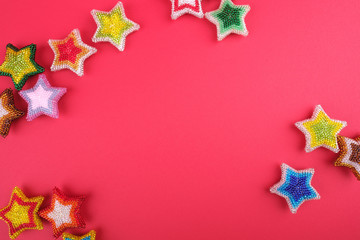 Christmas New Year star stars different colors made from beads handmade on red pink background
