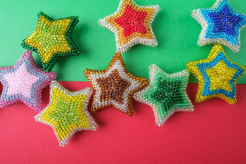 Christmas New Year star stars different colors made from beads handmade on green and red pink background