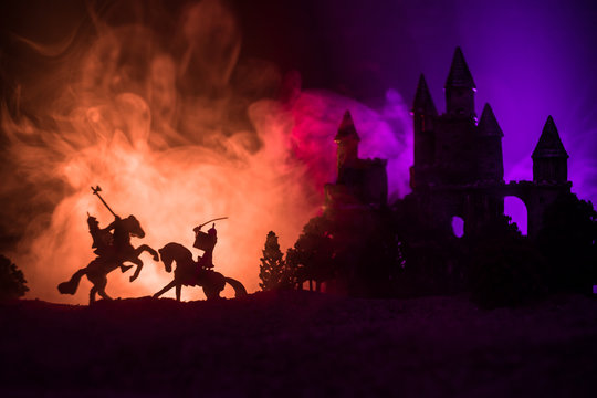 Silhouettes of figures as separate objects, fight between warriors on dark toned foggy background with old gothic castle