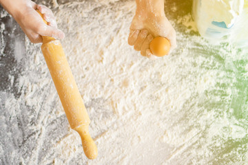 chef cook holding egg and preparing dough on the table top view f