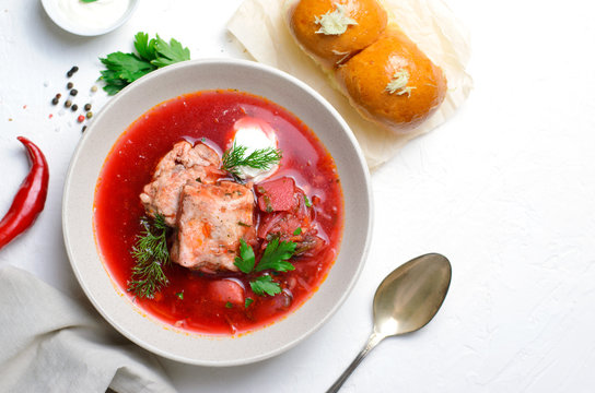 Borscht, Red Soup Made of Beetroot and Vegetables with Pork Ribs and Sour Cream Served with Garlic Rolls, Ukrainian, Russian and Polish Traditional Dish