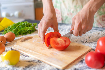 close up cook hands with knife cut tomato on the wooden board cooking dish f