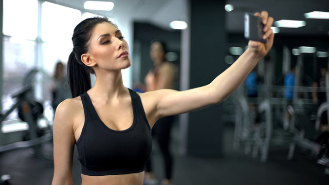 Young sport woman taking selfie after gym workout, social media platform