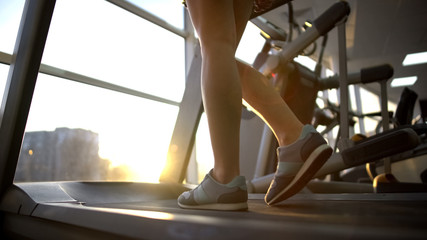 Female athlete legs walking treadmill machine, cardio exercise, active lifestyle