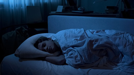 Nice young boy sleeping deep in his bed after hard day at university, relaxation