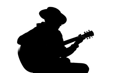 Silhouette of young male in hat playing guitar at party, cool hobby, recreation