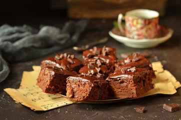 Pieces of chocolate cake with chocolate glaze on a rustic saucer