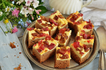 Pieces of rhubarb cake on a rustic tray on a wooden background