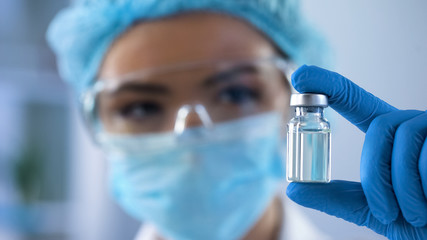 Female biologist holding bottle with new medication, vaccination lab research - 233949974
