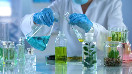 Scientist preparing liquid for experiments, testing new mixture for aromatherapy