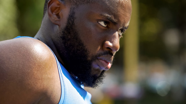 Face of sweating Afro-American athlete seriously looking forward, motivation