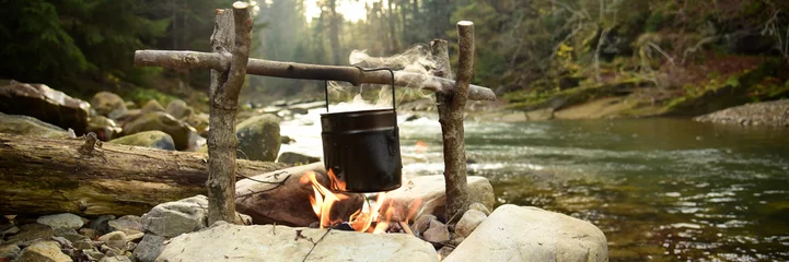 Kochen im Topf über dem Lagerfeuer im Freien © plysuikvv