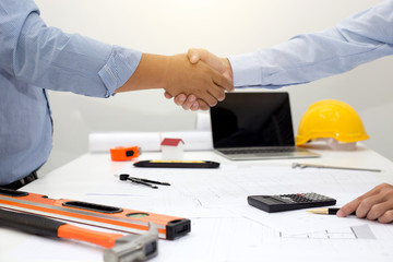Architect and businessman shaking hands meeting discuss a plan about the construction project of...