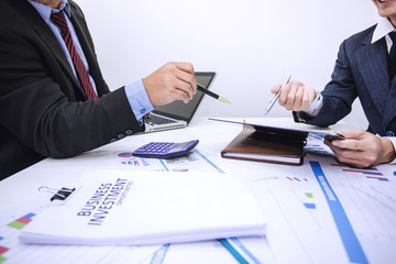 Two business people pointing graph analyze and discuss the situation on the financial report paper.