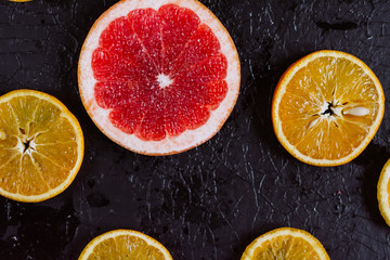 Delicious various types fresh cut of citrus fruit  on dark background.  Healthy eating, dieting.