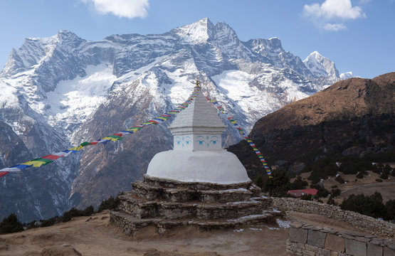 Buddhist white stupa with prayer flags above Namche Bazaar in Nepal Himalayas