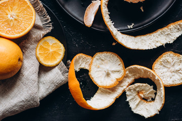 Delicious various types fresh of citrus fruit in plates on dark background