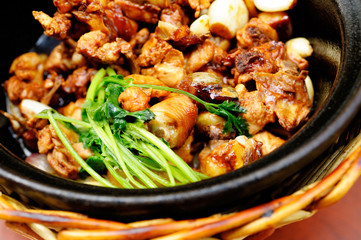 Chinese meat dish served in cooked directly on fire bowl.