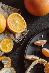 Delicious various types fresh of citrus fruit in plates on dark background