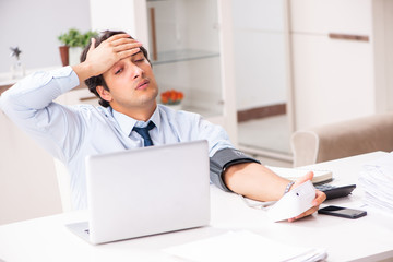 Fototapeta premium Man under stress measuring his blood pressure