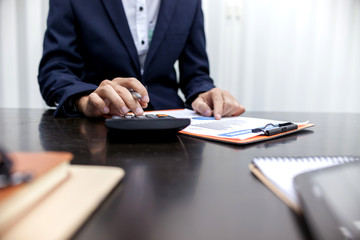 Business man using a calculator to calculate the turnover for businesses.