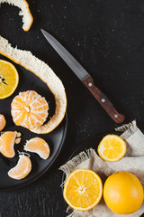 Delicious various types fresh cut of citrus fruit in plates on dark background