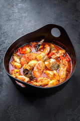 Traditional French Corsican seafood stew with prawns, mussels and fish as top view in a modern design Japanese cast-iron roasting dish
