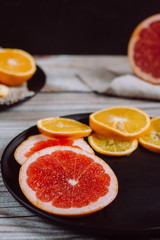 Fototapeta na wymiar Delicious various types of citrus fruit in plates on wooden background