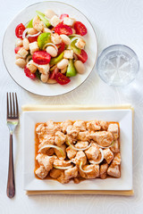 Turkey stew in tomato mustard sauce with onion on square plate