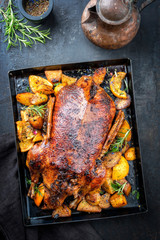 Traditional roasted Christmas duck with fruits and potatoes as top view on a board