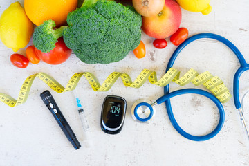 raw vegetables with blood glucose meter, syringe, lancet and stethoscope on desk, diabetes healthy...