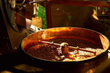 Roasting coffee. Coffee beans in a roasting machine. Cropped shot, close-up, horizontal, background. Concept of production and industry