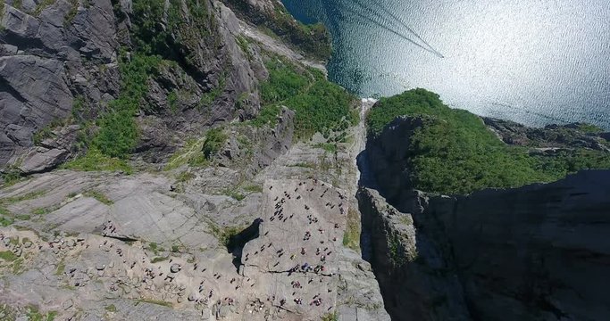 A lot of tourists are on Preikestolen famed 604-metre cliff with flat top. Natural attraction also known as Preacher's Pulpit, Preacher&rsquo;s Chair in Rogaland, Norway. Top view from drone