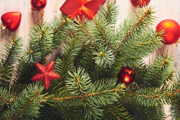 Christmas background. Fir tree and a lot of christmas red baubles and gift box