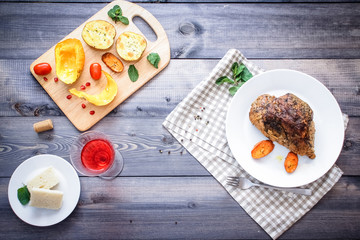 A large piece of baked meat Still life on a light wooden table.
