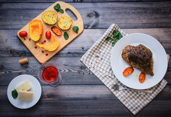 A large piece of baked meat Still life on a light wooden table.