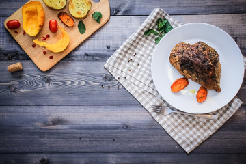 A large piece of baked meat Still life on a light wooden table.