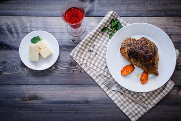 A large piece of baked meat Still life on a light wooden table.