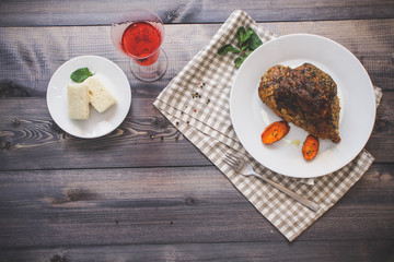 A large piece of baked meat Still life on a light wooden table.