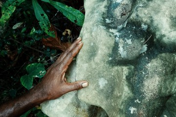 local villagers hand with a rock which was used to inspect human intestines while cannibalism was practiced