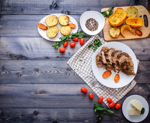 A large piece of baked meat Still life on a light wooden table.