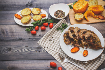A large piece of baked meat Still life on a light wooden table.